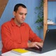 A Young Man with Working From Home at the Notebook in Cozy Room - VideoHive Item for Sale