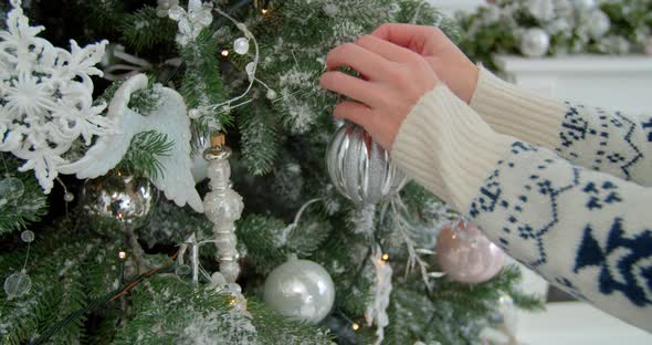 Woman Hangs Christmas Balls for the New Year and Christmas Holidays. Close-up Hands Hang a Christmas alt