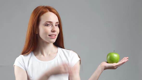 Attractive Redhead Girl with Green Apple. Healthy Fitness and Eating Lifestyle Concept alt