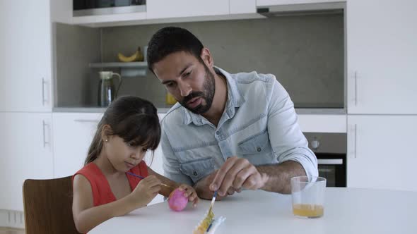 Little Girl and Her Dad Painting Egg Together alt