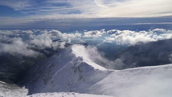 Snowy Alpine Mountains in Sunny Winter Above Clouds alt