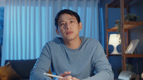 Asia businessman looking at camera focus online video call meeting assignment work with colleague. alt