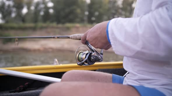 a man catches fish on a fishing rod from a boat