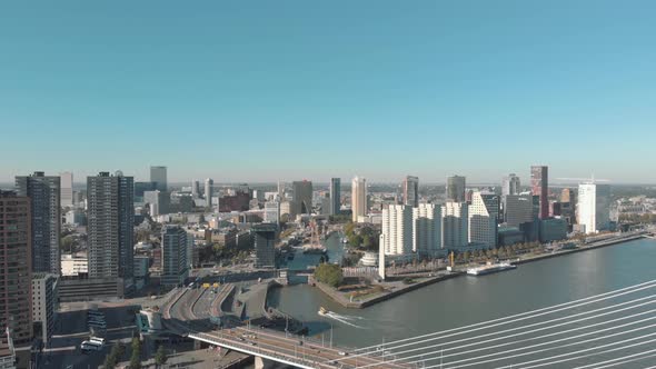 Drone footage of a slow right pan of the city of Rotterdam and it's water channel on a sunny day alt