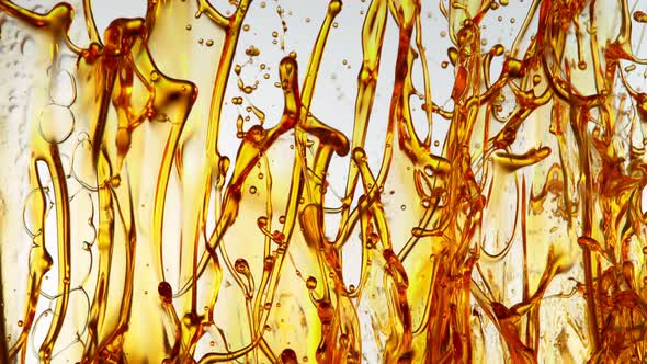 Super Slow Motion Shot of Splashing Golden Oil on White Background at 1000Fps alt