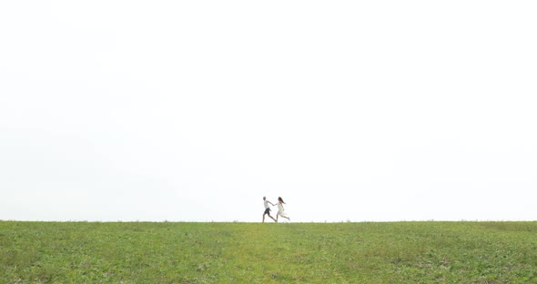 Happy Couple Running on Field alt