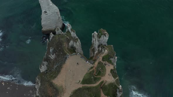 Tourists on Viewing Platform Above Etretat Cliffs, Aerial Tilt Down View alt