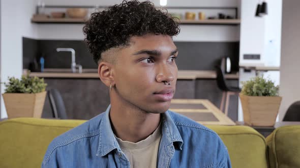 Portrait of Beautiful Stylish African American Young Man Serious at Camera on Home Interior alt
