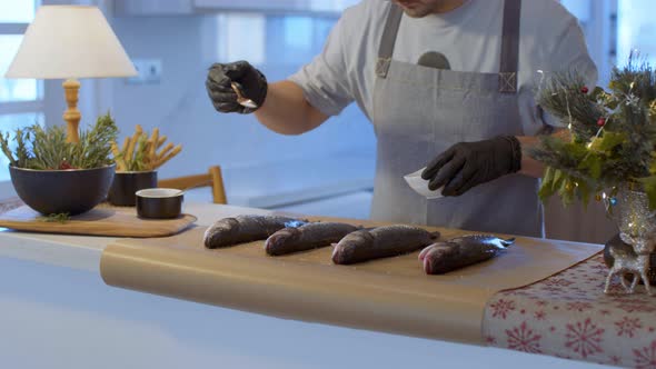 Man’s Hands Salts Raw Fish On The Table alt