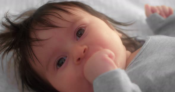 Portrait of a Cute Newborn Toddler Lying in a Crib