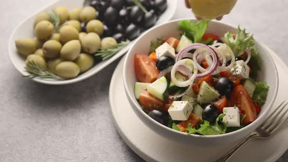 A man squeezes the juice of half a lemon into a salad