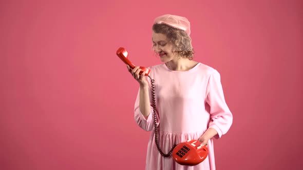 Smiling Woman Talking on Retro Telephone Isolated on Pink. Portrait of Young Pretty Woman Pinup Girl alt