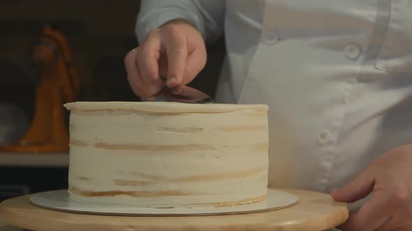 The Male Pastry Chef Aligns the Shape of the Cake By Rotating It in a Circle