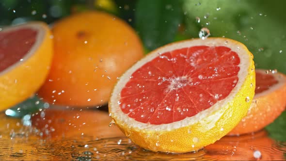 Super Slow Motion Shot of Water Droplets Falling on Fresh Pink Grapefruit at 1000Fps alt