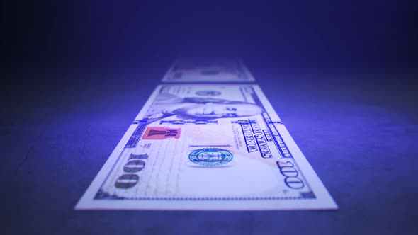 American dollars checked by the UV light detector. Searching for fake money. 4K alt