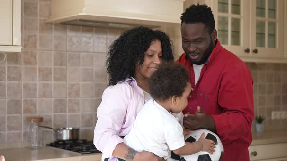 Toddler Boy Passing Soccer Ball in Slow Motion to Happy Young African American Father As Cheerful alt