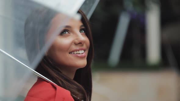 Portrait of Smiling Woman Under Umbrella in City Looking Looking Sideways alt