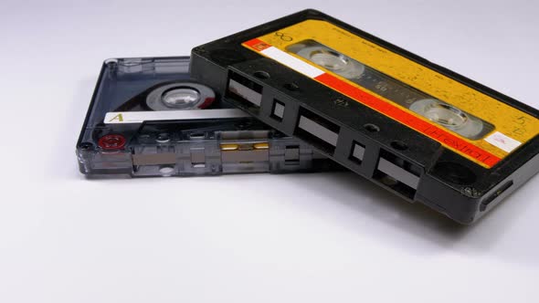 Two Vintage Audio Cassette Rotates on White Background alt
