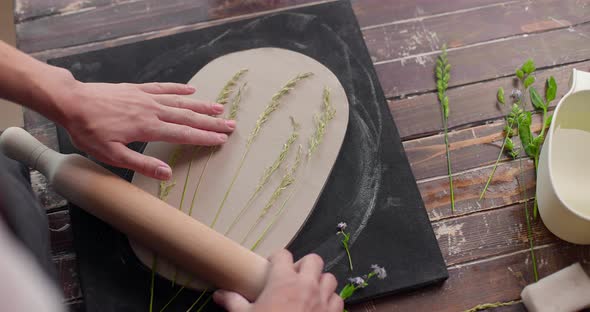 The Master Leaves the Imprint of the Plants on the Clay Board in Pottery Studio alt