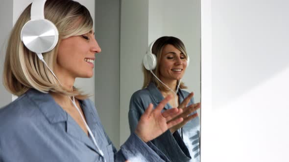 Portrait of cheerful european woman in headphones listening to music