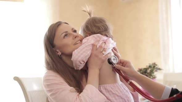 Beautiful Mother with Daughter Making Appointment to Doctor