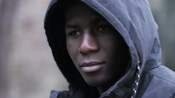 Confident attractive young african black man with hood looking at camera-outdoor alt