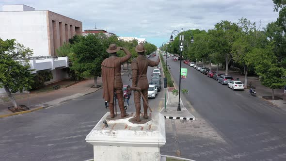 Aerial pull back and from the monument to Francisco de Montejo and his son, showing the Paseo Montej alt