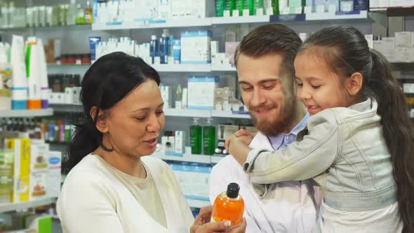 Apothecary with a Girl in Her Arms and Her Mother Choose a Remedy in a Pharmacy