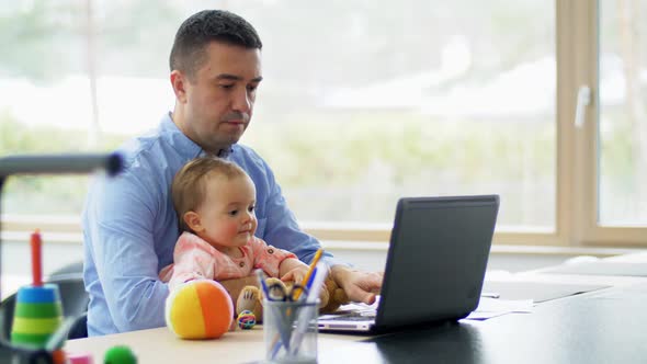 Father with Baby Working on Laptop at Home Office alt
