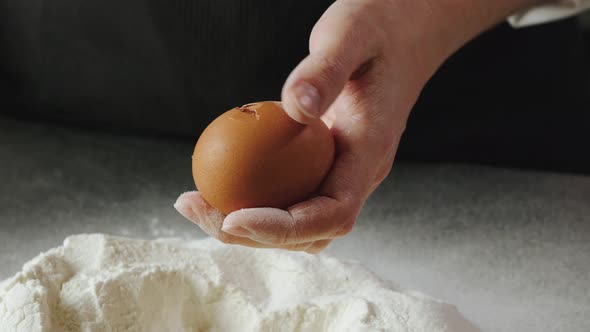 The Cook Cracks the Egg and Adds It to the Flour