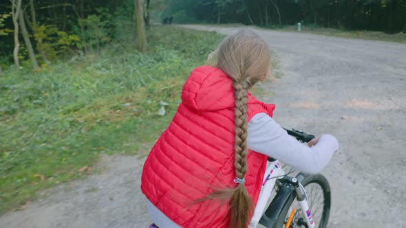 Girl Riding a Bike Near the Forest alt