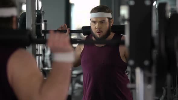 Fitness Club Member Doing Squats With Barbell, Satisfied With His Progress alt