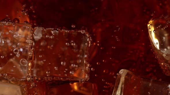 Super Slow Motion Detail Shot of Fizzing Cola Lemonade and Floating Ice Cubes at 1000 Fps alt