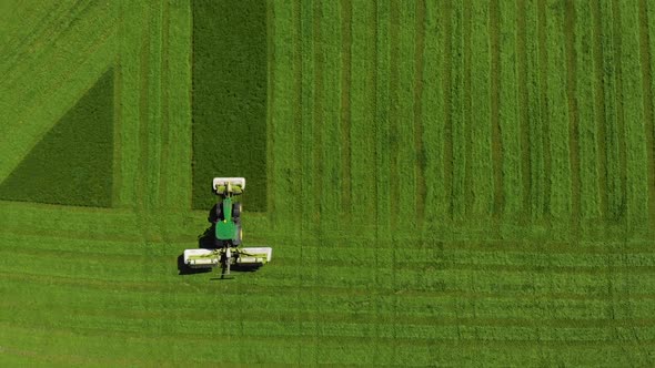 Aerial View of Green Tractor Harvesting Agricutlural Field of Wheat alt