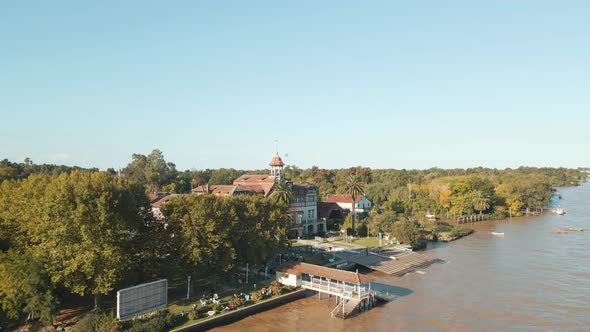Aerial orbit of Tigre exclusive rowing club beside de la Plata river surrounded by trees at golden h alt