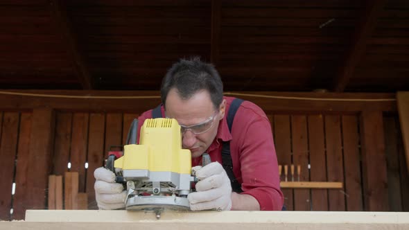 Woodworker Cutting Wooden Beam with Milling Machine in Diy Carpentry Workshop alt
