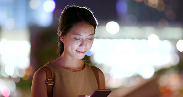 Woman use of mobile phone in city at night alt