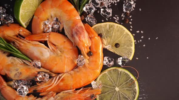 Top View of Fresh Prawns in Ice Rotates on Black Tray