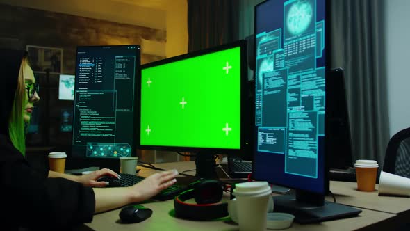 Zoom in Shot of Hacker Girl in Front of Computer with Green Screen alt