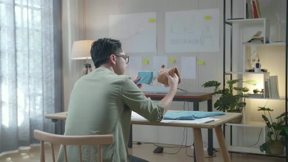 Back View Of A Man Bag Designer With Layout Bond Looking At The Fabric In Hands alt