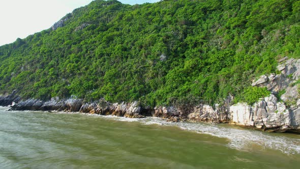 4K aerial view of mountain coast near beautiful beach and sea. Flight over sea. alt