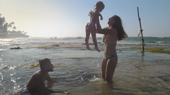 Nice Woman Tosses Daughter Above Ocean Making Kid Smile alt