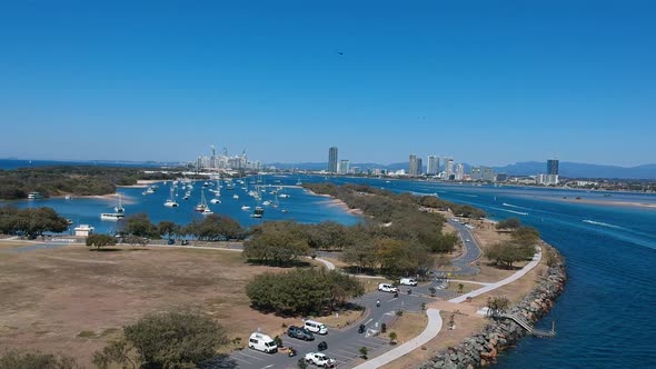 Aerial view of a busy day on popular waterway with a city skyline in the distance alt