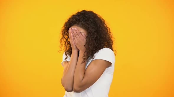 Frightened Biracial Woman Watching Horror Movie, Closing Face With Hands, Fear alt