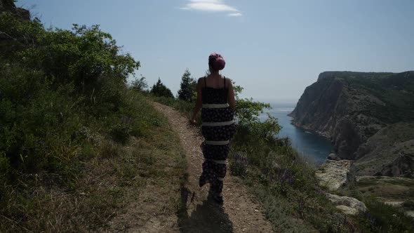 A Mysterious Woman in a Long Summer Dress Walks on a Mountain Serpentine