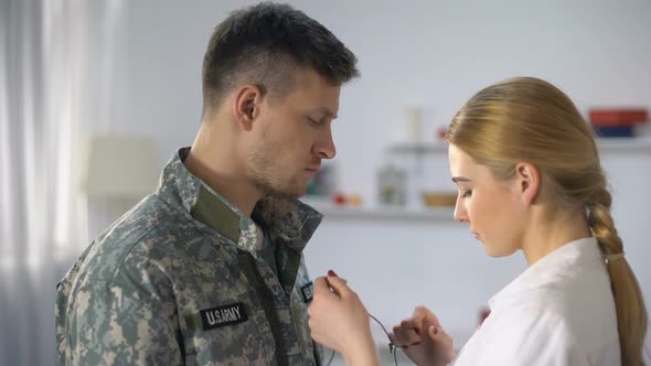 Upset Woman Wearing Wooden Cross Necklace on Male Soldier and Hugging, Farewell alt