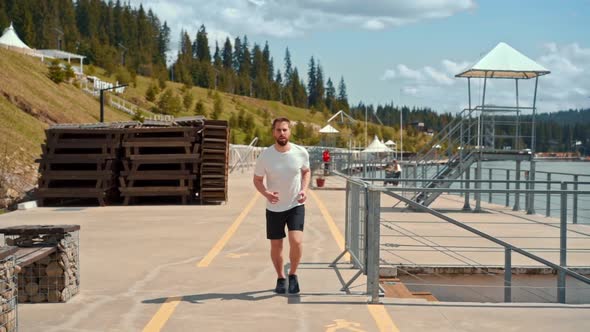 Young man running fast and intense in forest alt