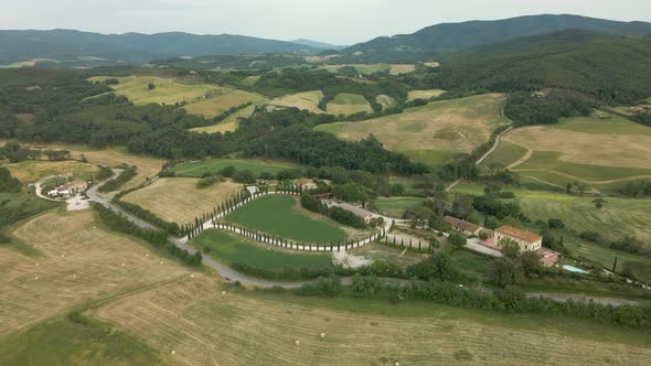 Aerial images of Tuscany in Italy cultivated fields summer, I fly forward over a heart-shaped farm alt