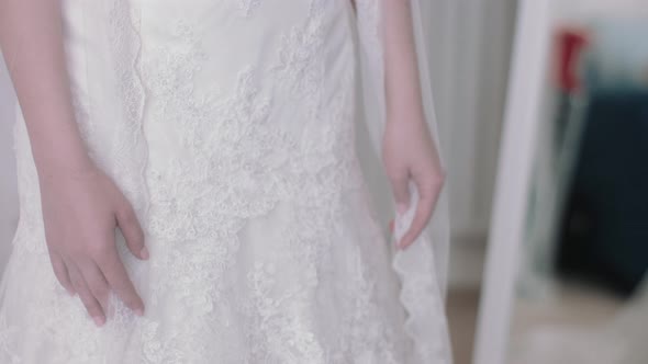 Young bride admiring herself in wedding dress