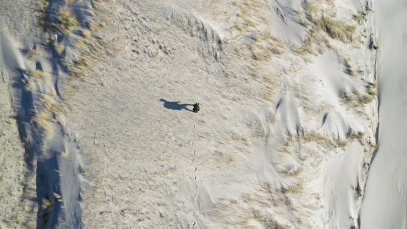 Aerial View Of Traveler Walking On Sandy Dunes At Seaside